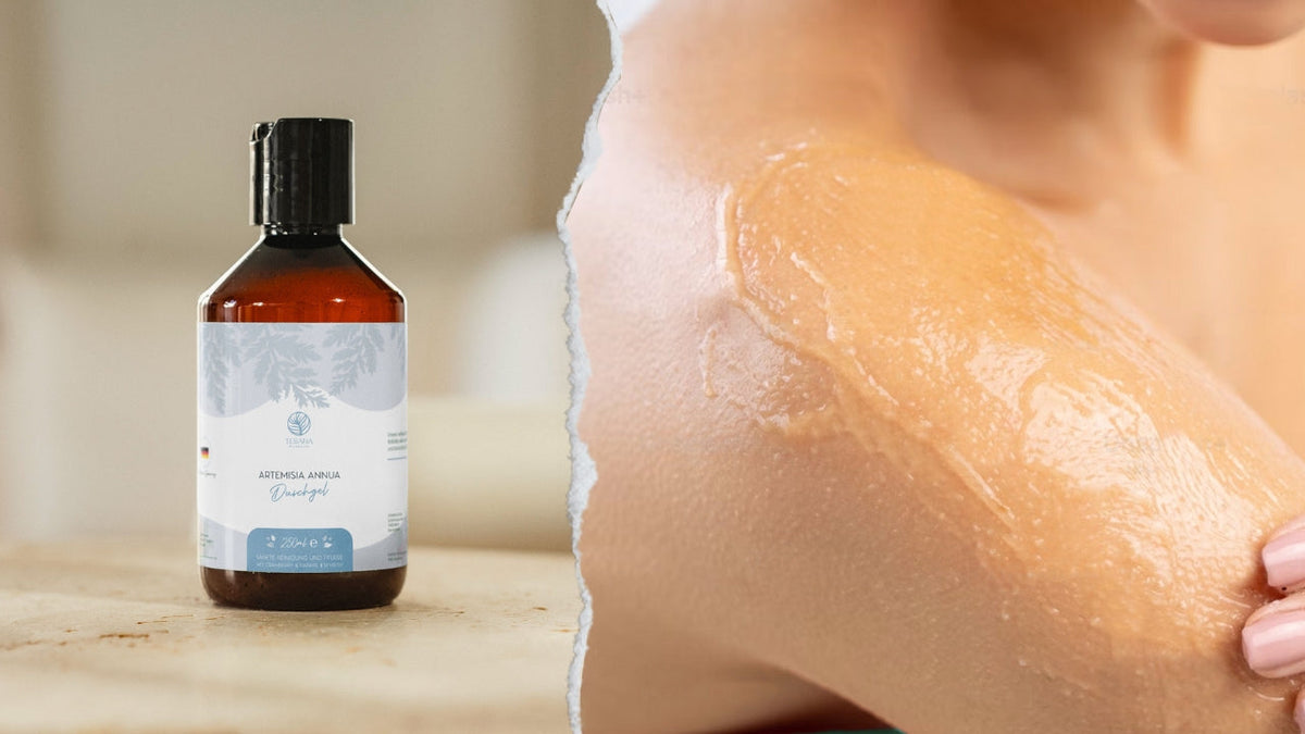 Eine braune Flasche Artemesia Annua  A-3 Duschgel von Teemana. Sie Steht auf einer hellen Steintischplatte, im Hintergrund, stark verschwommen, sieht man verschiedene Möbel einer Wohnungseinrichtung